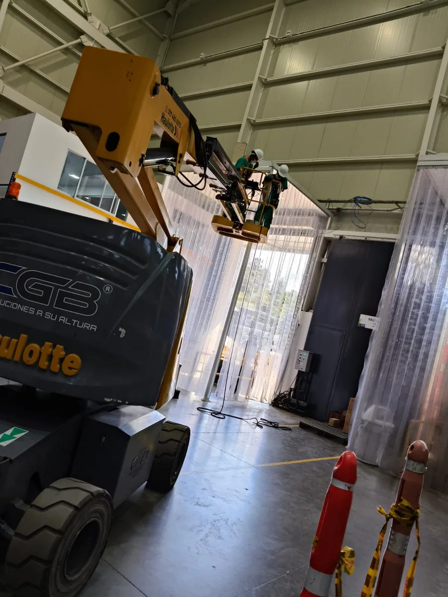 Dos técnicos de Xanthia sobre una plataforma elevadora realizando una instalación en altura dentro de una bodega industrial