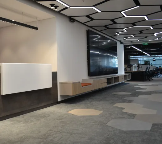 Recepción corporativa con iluminación arquitectónica hexagonal y videowall instalados por Xanthia