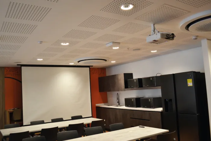 Sala de capacitación equipada con videoproyección, pantalla e iluminación LED empotrada